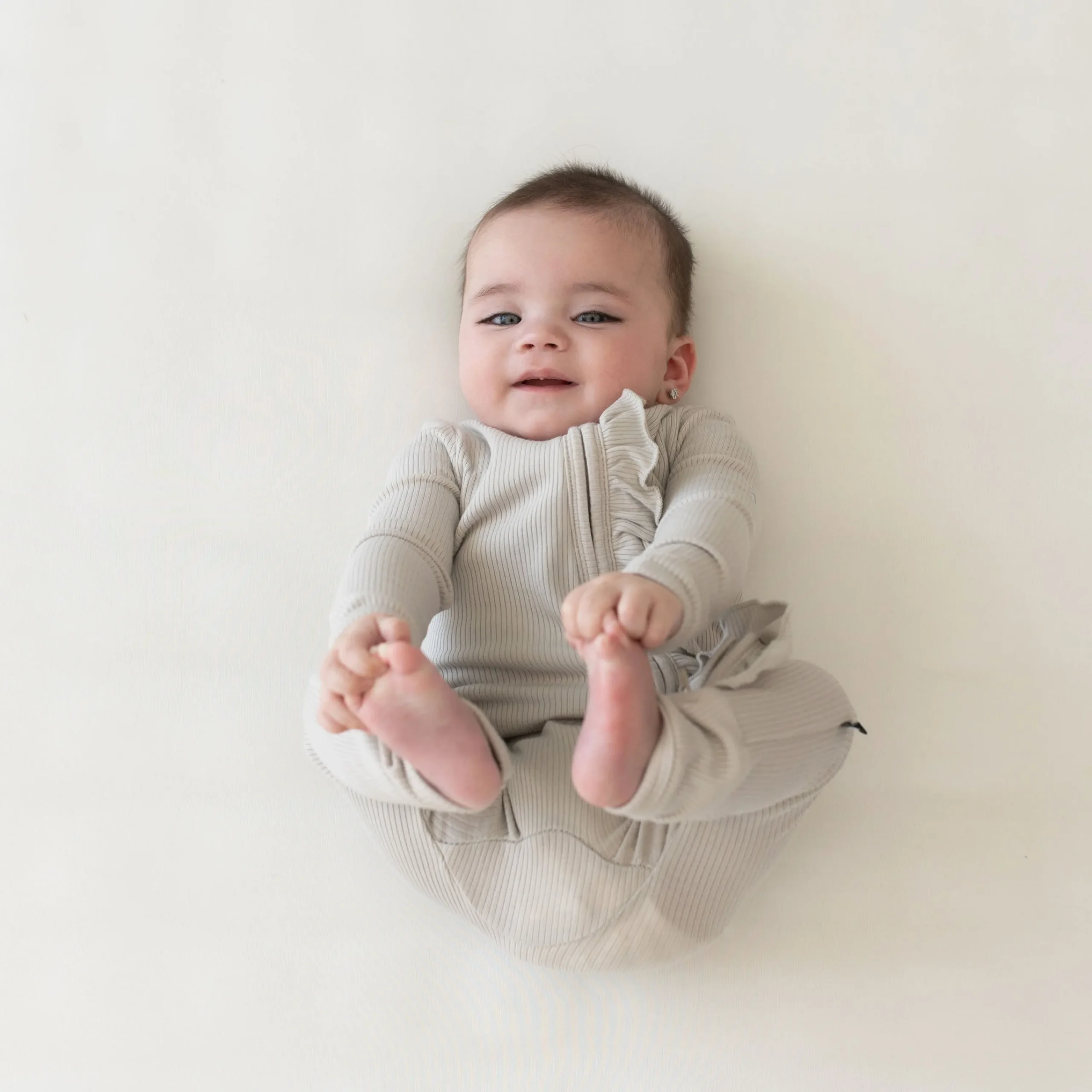 Kyte Baby Ribbed Ruffle Zipper Romper in Oat Clearance